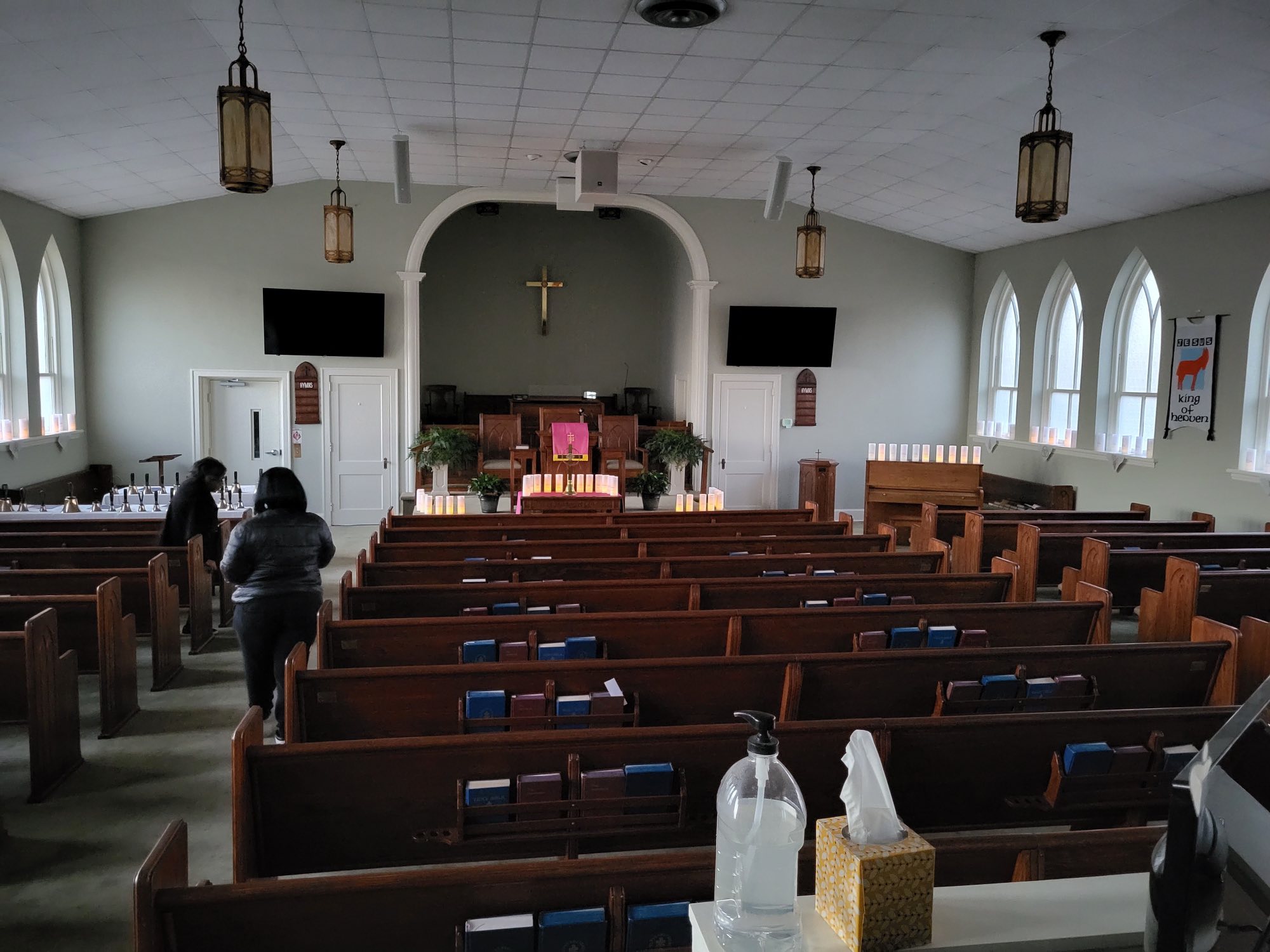 Sanctuary interior with pews, altar, candles, and cross